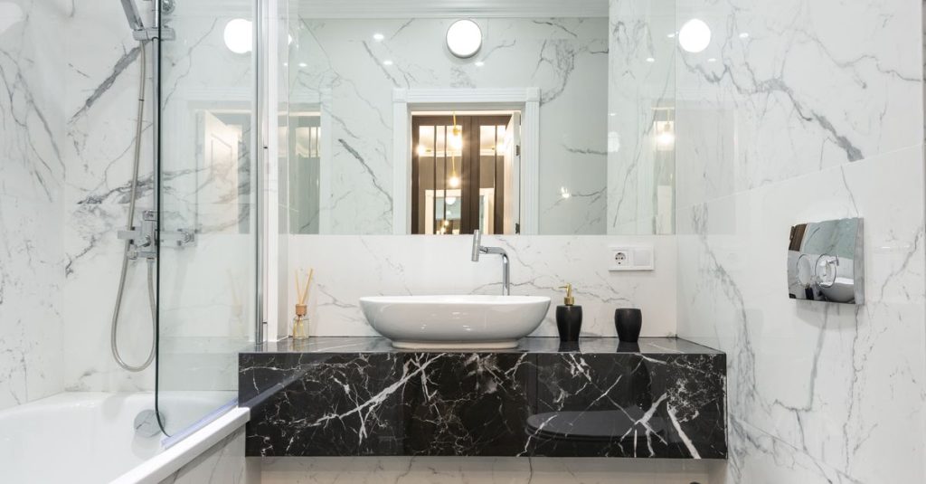 Luxurious bathroom featuring marble walls and floor with modern fixtures and minimalist design.